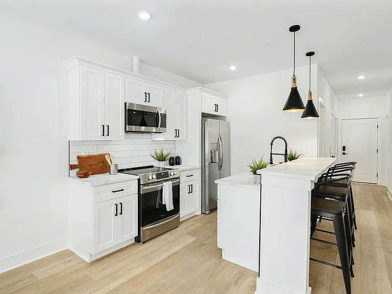 A kitchen with white cabinets and a black stove top.