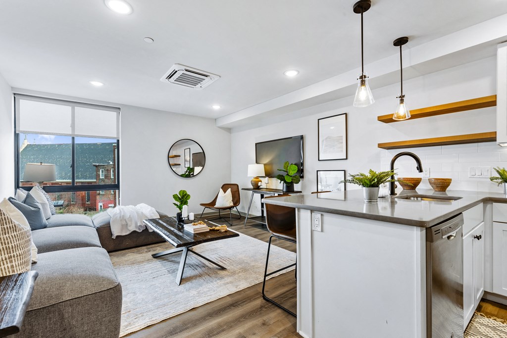 a living room with a couch and a kitchen