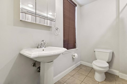 a bathroom with a toilet and a sink and a window