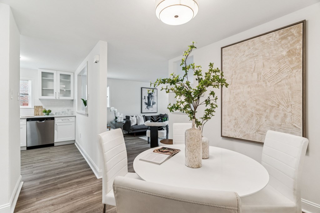 A dining room with a white table and chairs.