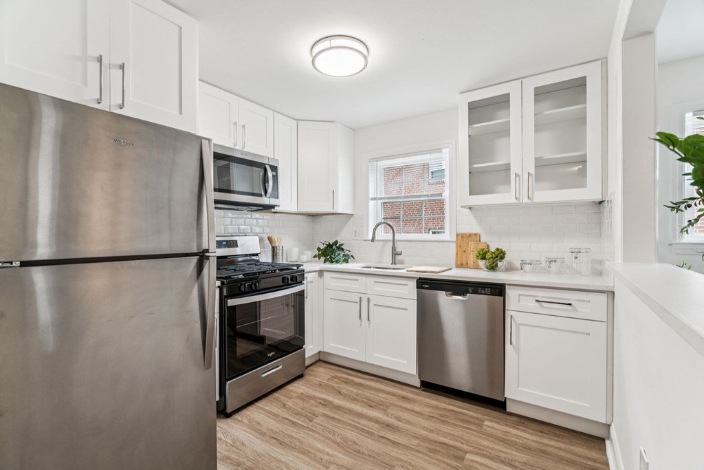 A kitchen with a stainless steel refrigerator, microwave, oven, and dishwasher.