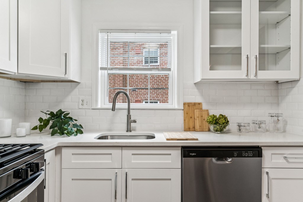A modern kitchen with white cabinets and a stainless steel dishwasher.
