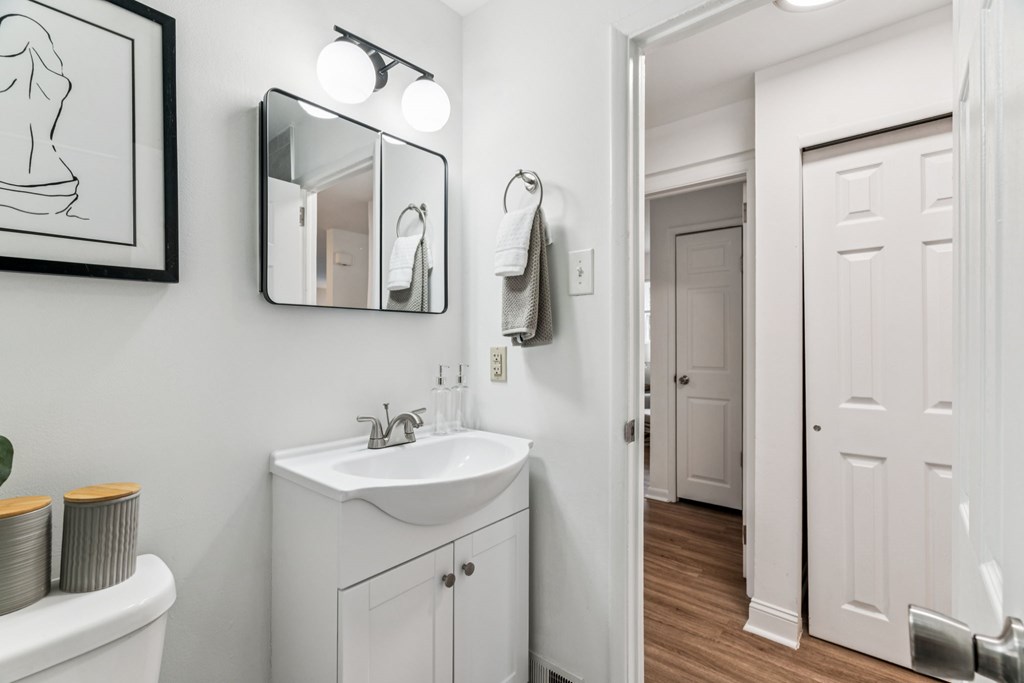 A bathroom with a white sink and a white toilet.