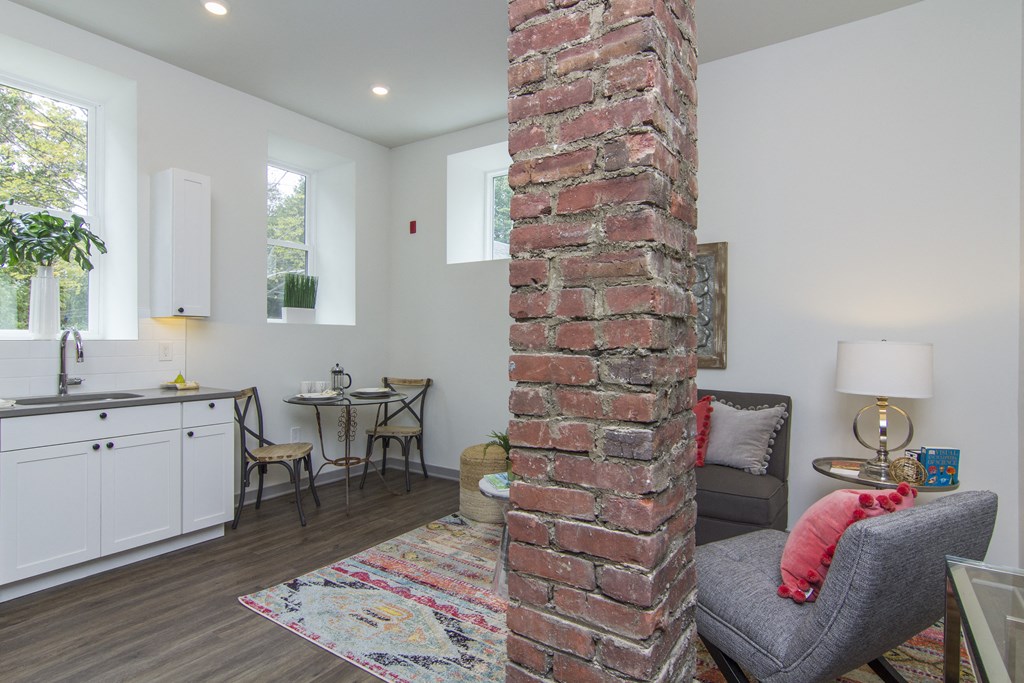 a living room with a brick column in the middle of the room
