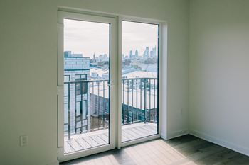 A view of a cityscape is visible through a large glass door.