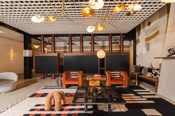 a living room with a black and white rug and a table with chairs
