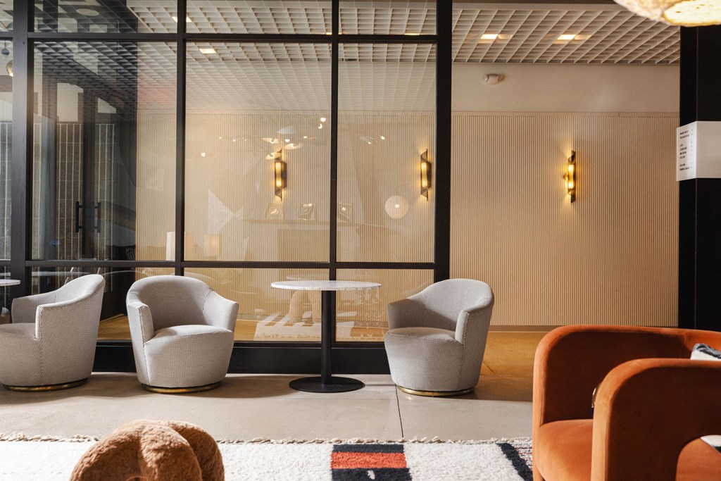 a seating area with chairs and a table in front of a window