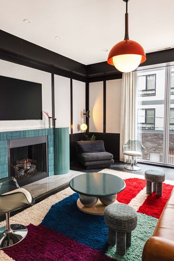 a living room with a fireplace and a colorful rug