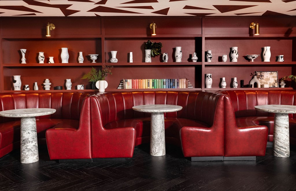 a red booth with red chairs and tables in a restaurant