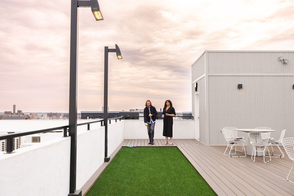two people standing on the roof of a building with grass