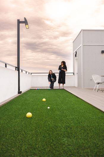 two women on a roof terrace with balls on the grass