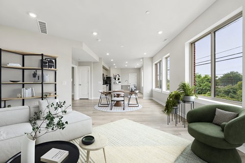 A living room with a white sofa, a green armchair, and a coffee table.