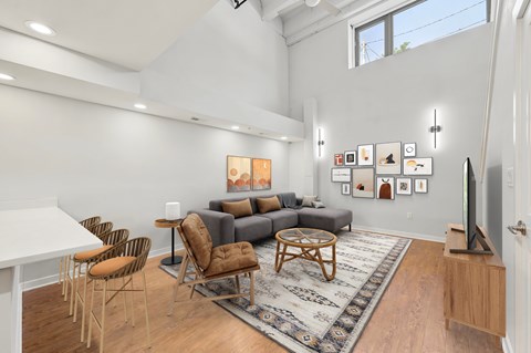 A living room with a grey couch and a white table.