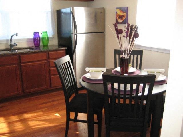 a kitchen with a table and chairs and a refrigerator