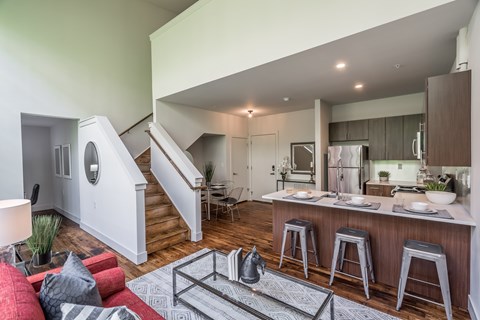 A modern kitchen with a bar stool and a dining table.