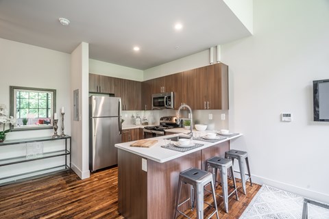 A modern kitchen with a wooden floor and white walls.