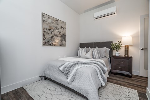 A bedroom with a large bed and a painting on the wall.