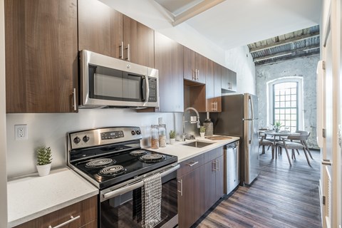 A kitchen with wooden cabinets and a black stove top oven.