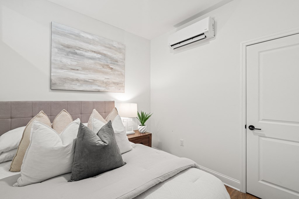 a bedroom with a large bed with white sheets and pillows