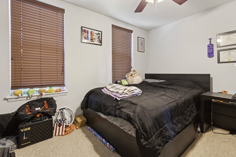 a bedroom with a bed and a window with blinds