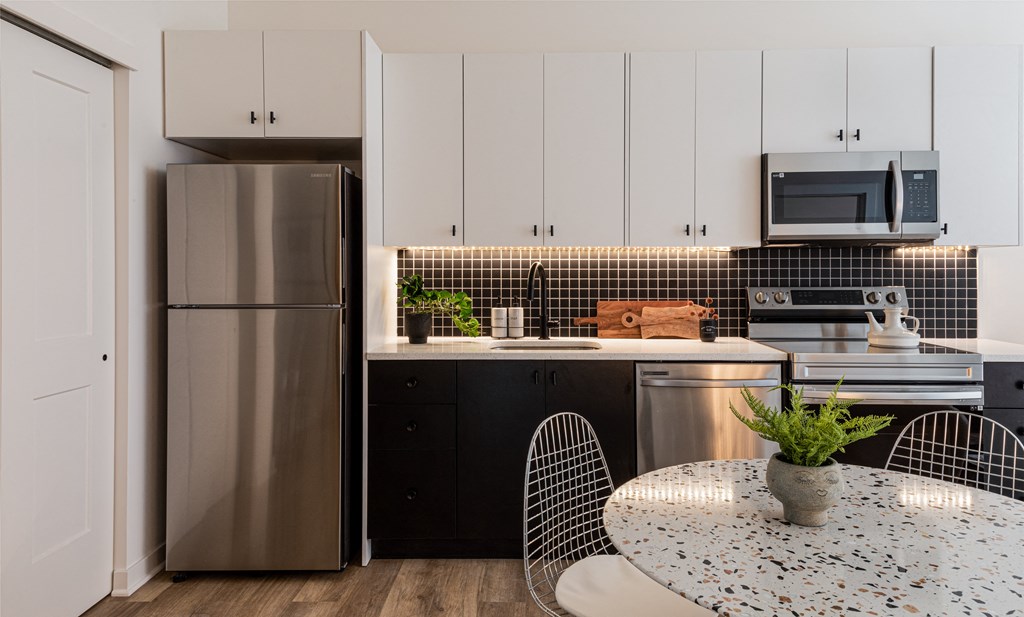 a kitchen with white cabinets and stainless steel appliances