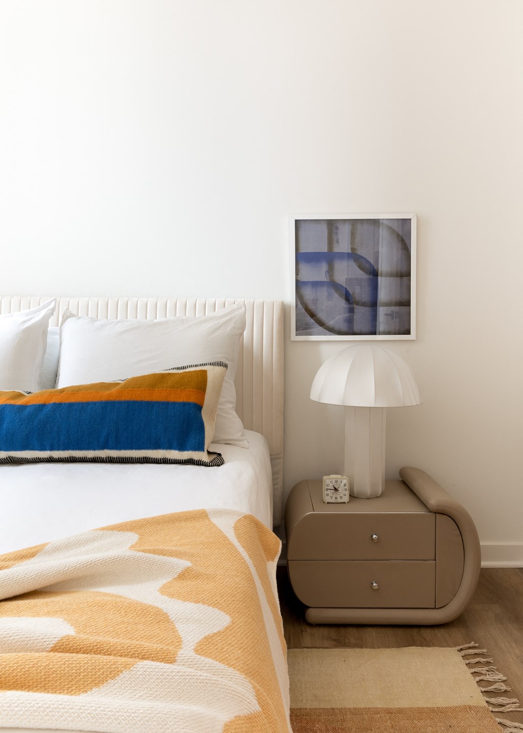 a bedroom with a bed and a nightstand with a lamp