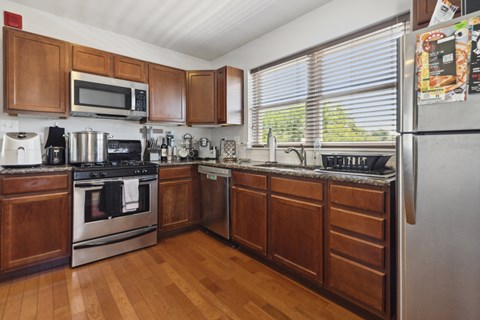 a kitchen with wooden cabinets and stainless steel appliances