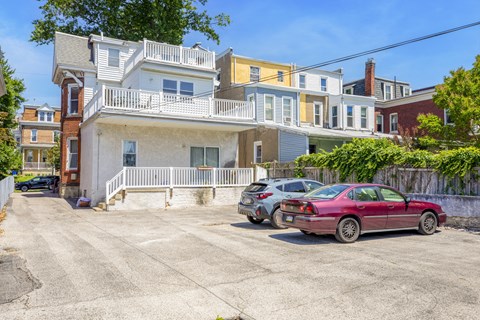 a house with a parking lot and two cars in front of it