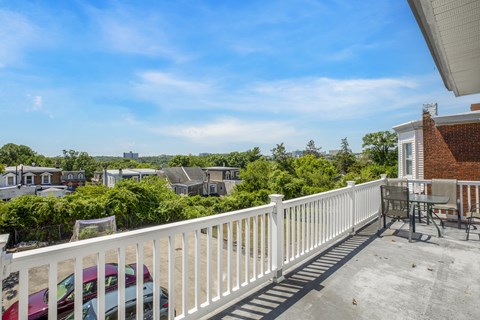 the view from the deck of a house with a white railing and chairs and a