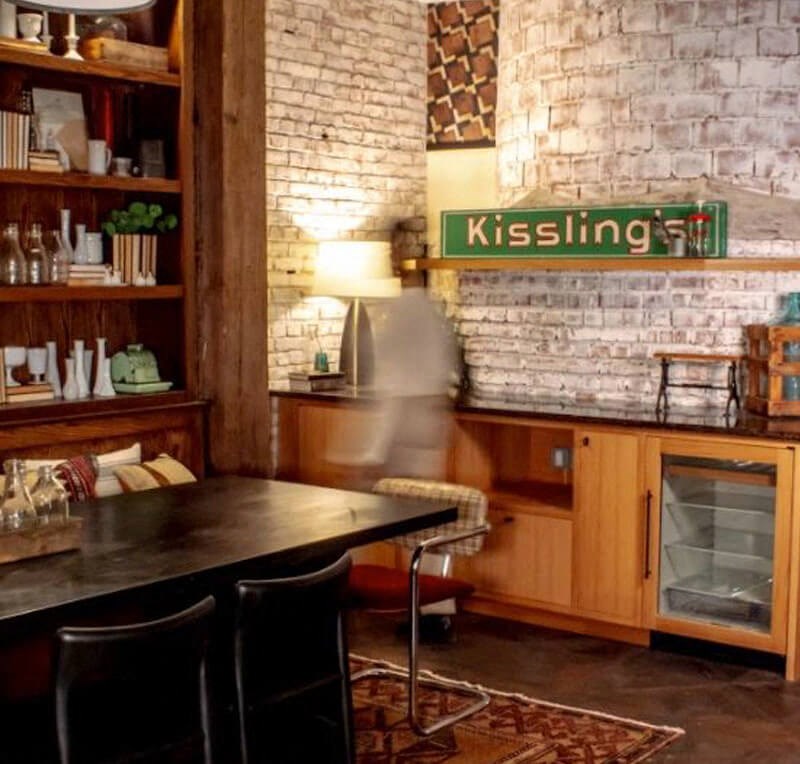 a table and chairs in a room with a brick wall
