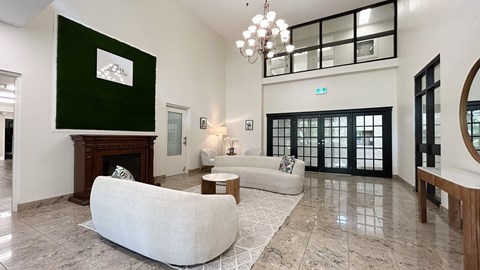 A living room with a white sofa and a fireplace.