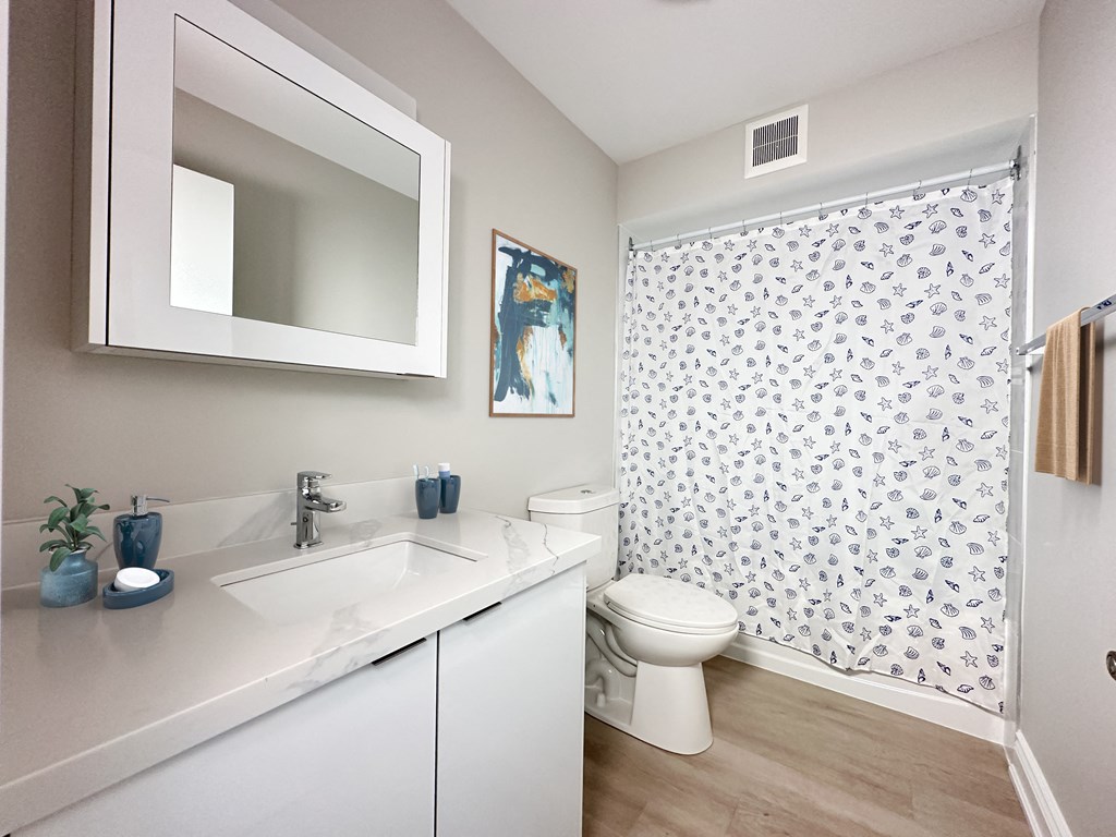 a bathroom with a shower and a toilet and a sink