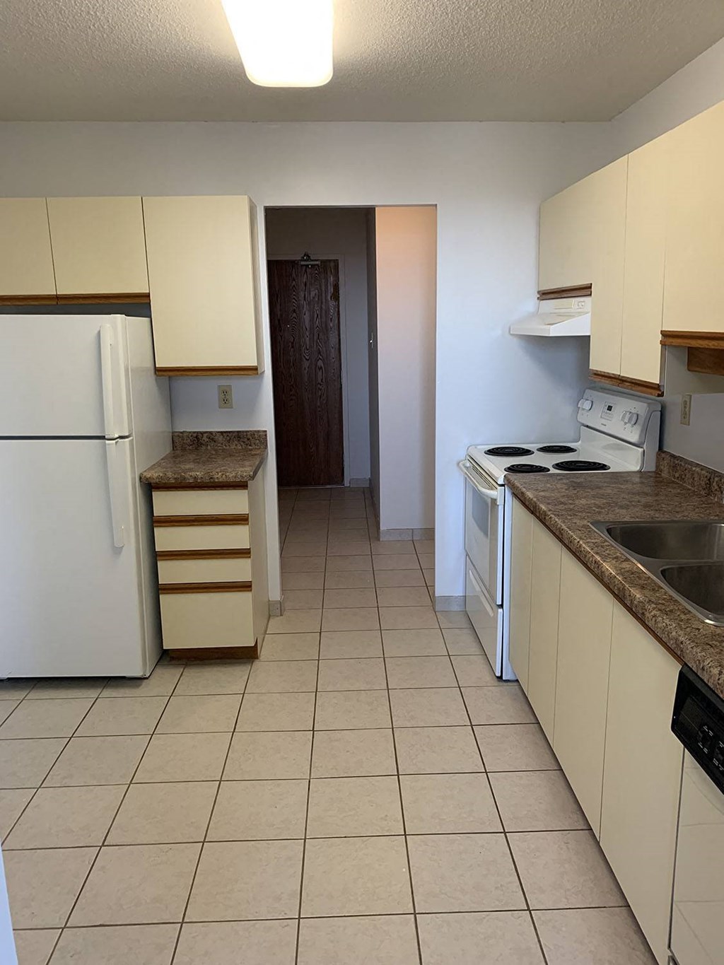 a kitchen with white cabinets and a refrigerator and a sink