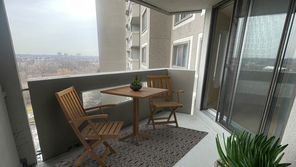 a small balcony with a table and chairs on it