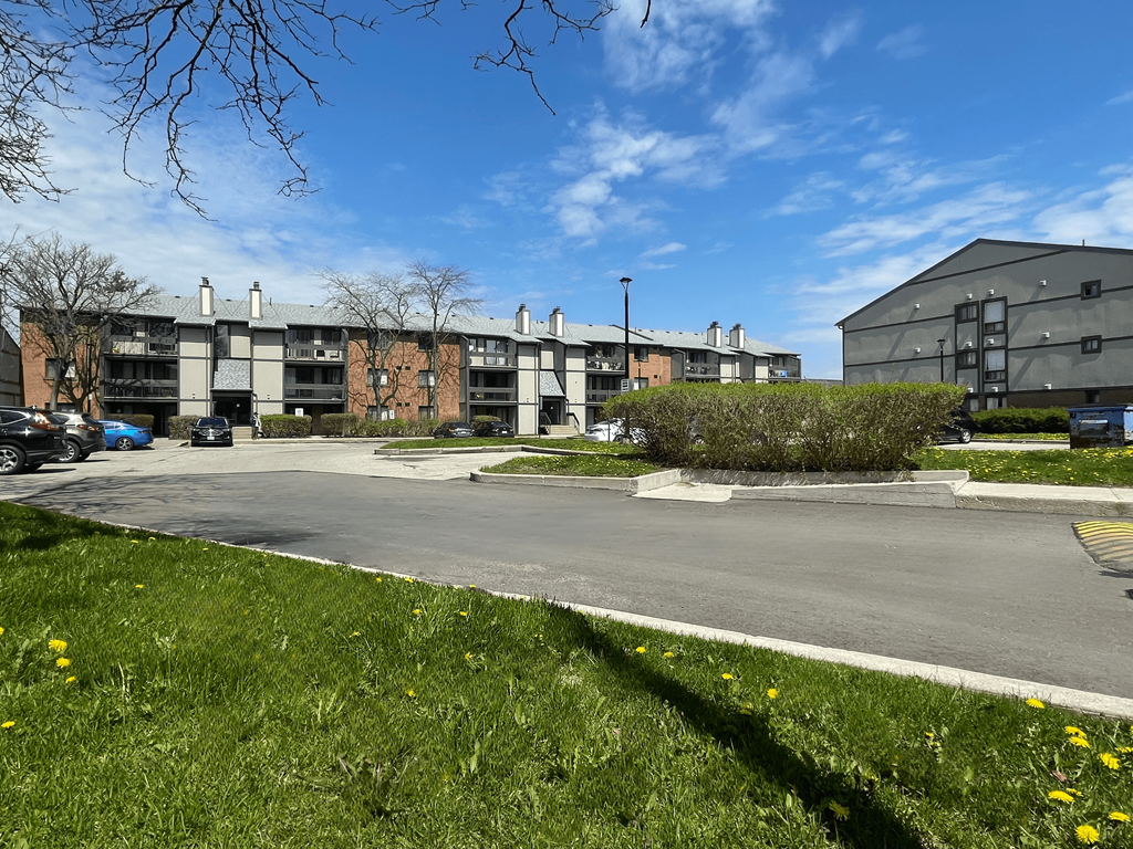 an empty parking lot in front of an apartment complex