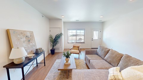 A living room with a brown couch and a painting on the wall.