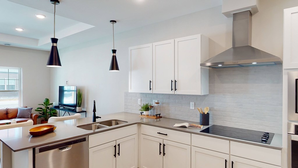 A modern kitchen with white cabinets and a stainless steel sink.