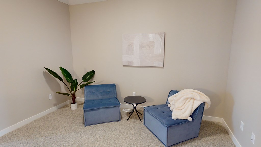 A living room with a blue chair and a small table.