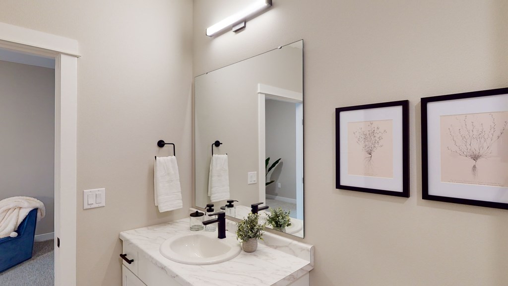 A bathroom with a white sink and a mirror above it.