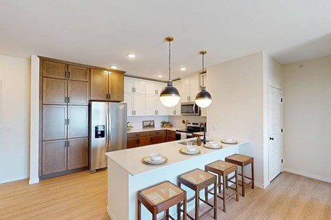 A kitchen with a white island and brown stools.