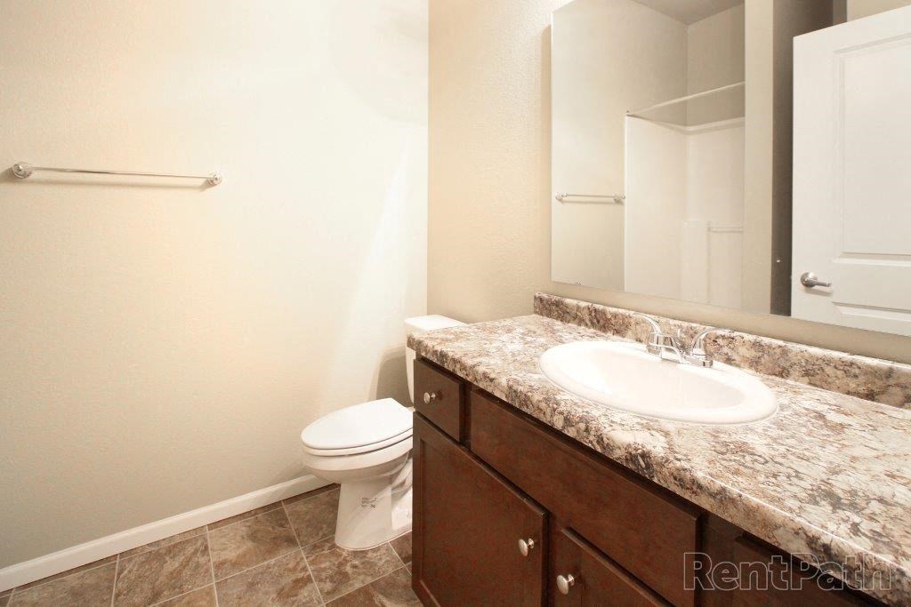 a bathroom with a sink toilet and a mirror