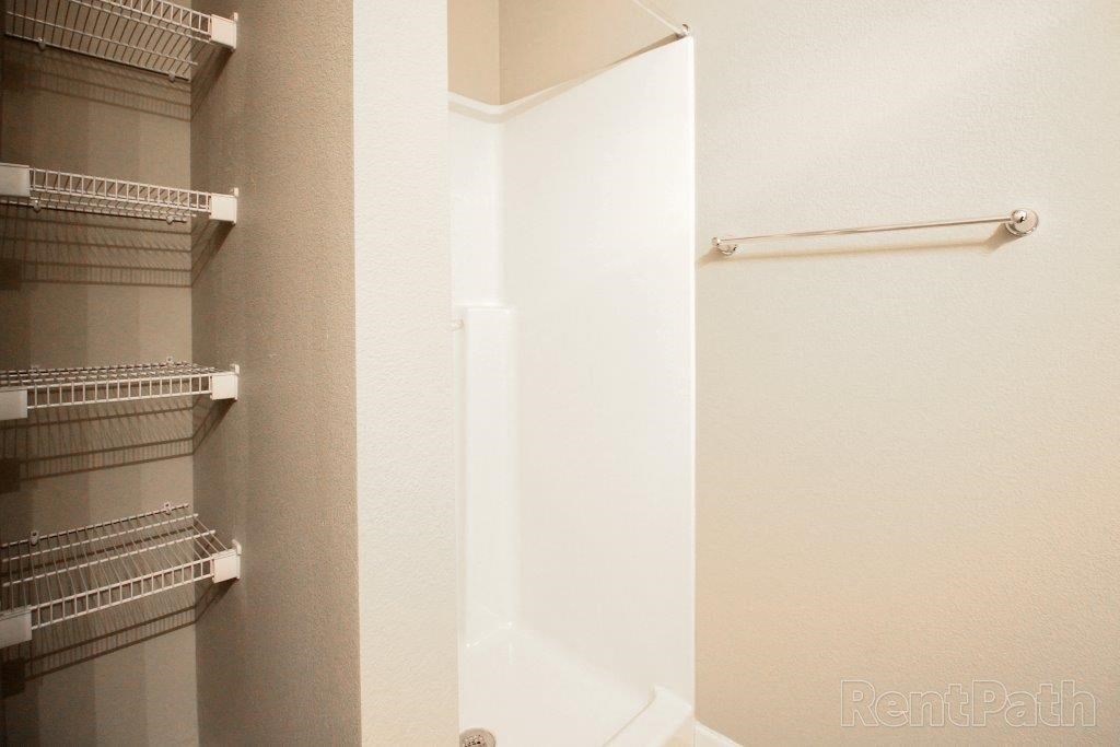 a bathroom with a shower and a towel rack