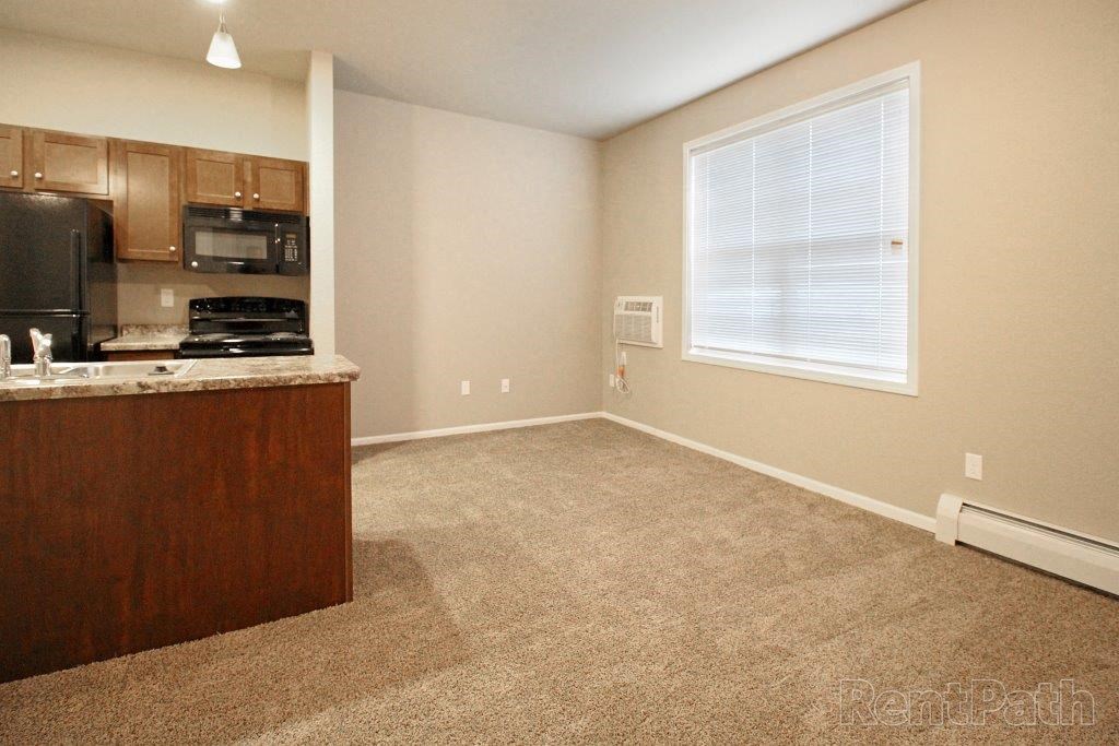 an empty room with a kitchen and a window