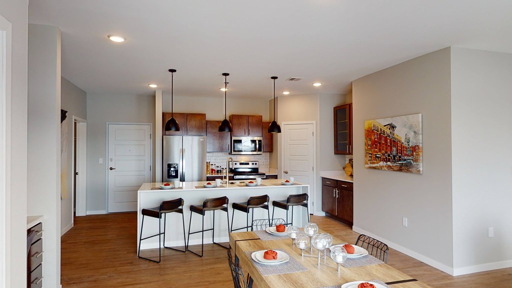 A modern kitchen with a dining table set for four.