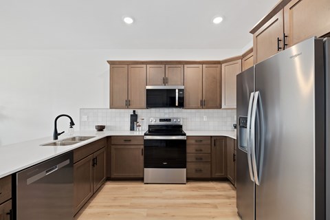 A modern kitchen with wooden cabinets and stainless steel appliances.