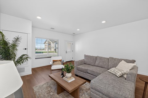 A living room with a grey couch and a wooden coffee table.
