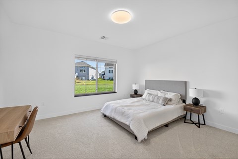 A bedroom with a large bed and a wooden table.