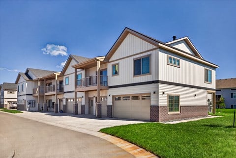 A row of modern houses with garages and driveways.