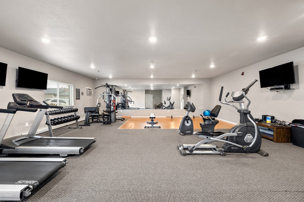 A spacious home gym with a variety of exercise equipment.