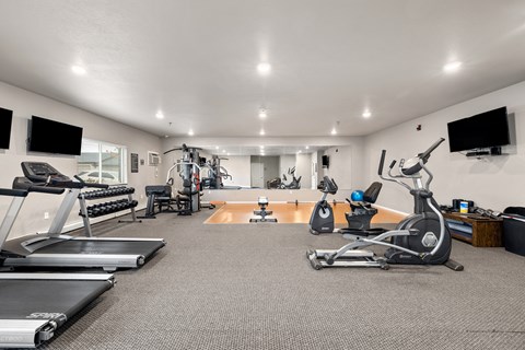 A spacious home gym with a variety of exercise equipment.